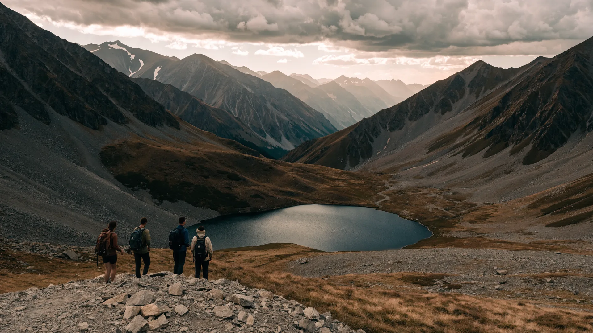 Four hikers approaching a remote high-altitude lake ringed by Kyrgyz mountains